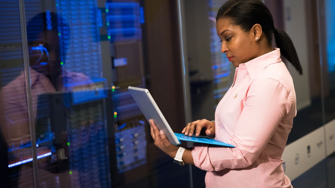 An engineer working on a laptop in a server room