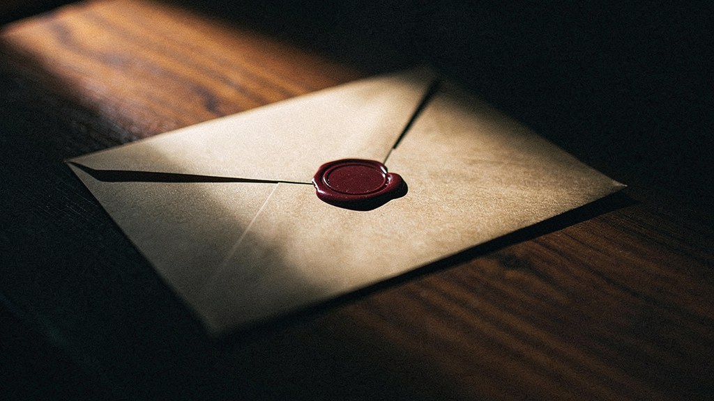 A sealed kraft envelope on a dark wood desk, representing Zerodium's shift to an invitation-only contact channel